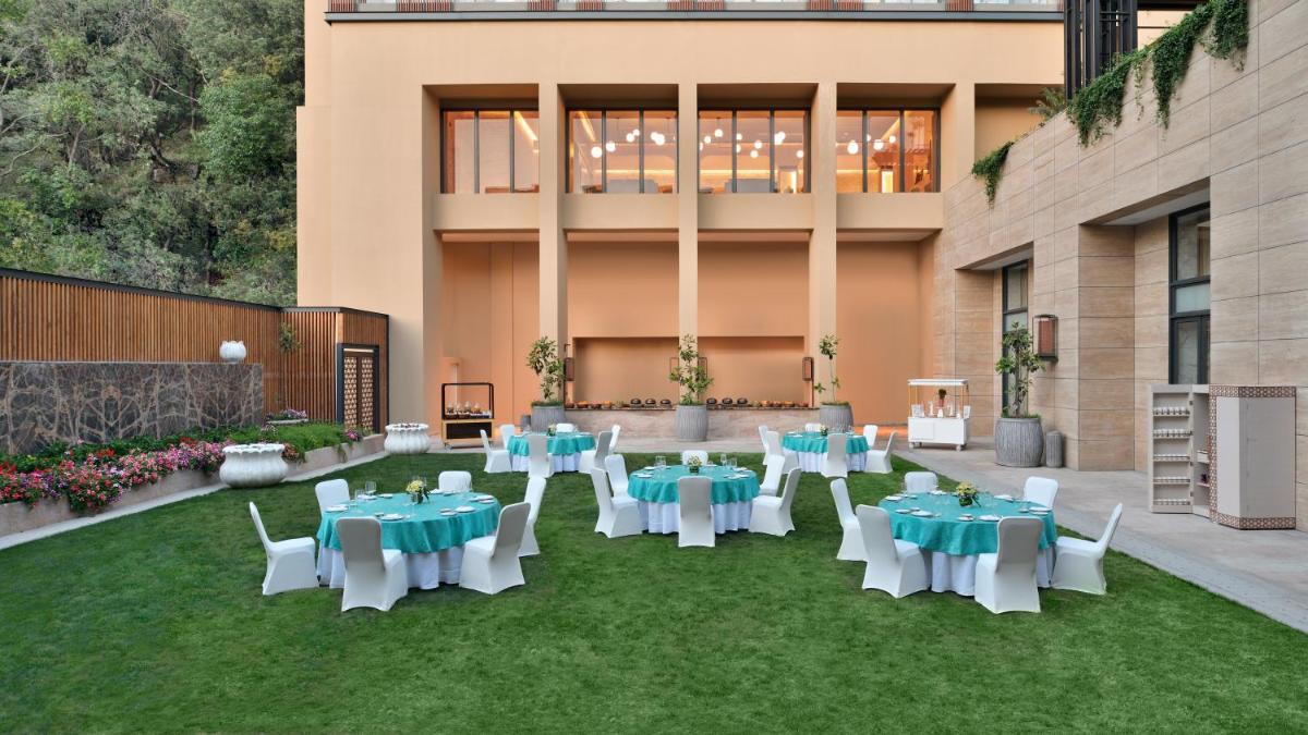 a patio with tables and chairs on the grass at The Westin Resort & Spa Himalayas in Rishīkesh