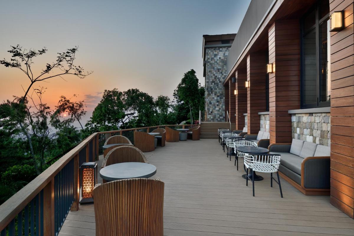 a balcony with tables and chairs on a building at The Westin Resort & Spa Himalayas in Rishīkesh