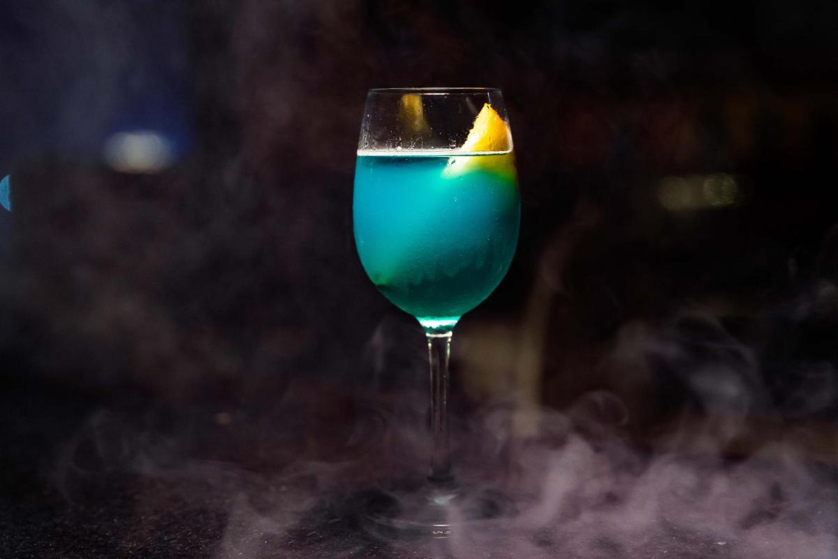 a glass with a blue drink with a lemon in it at The Crown Goa in Panaji