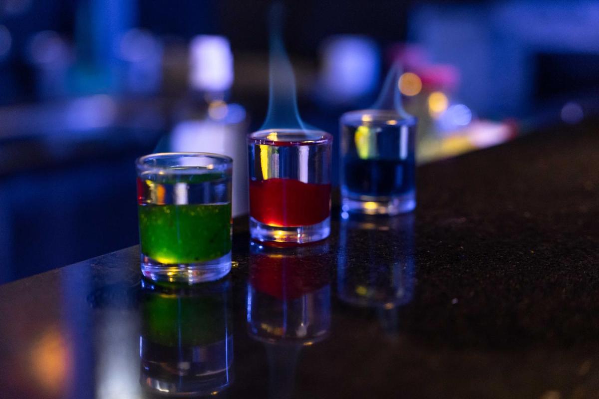 four glasses filled with colored liquids sitting on a table at The Crown Goa in Panaji