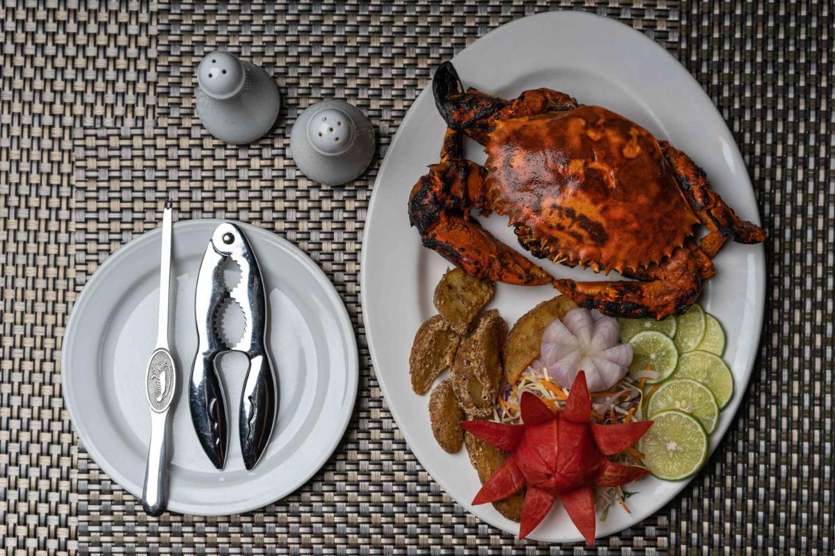 a plate of food with chicken and vegetables on a table at The Crown Goa in Panaji