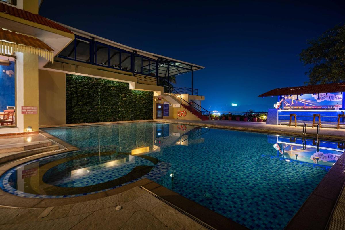 a swimming pool in a hotel at night at The Crown Goa in Panaji