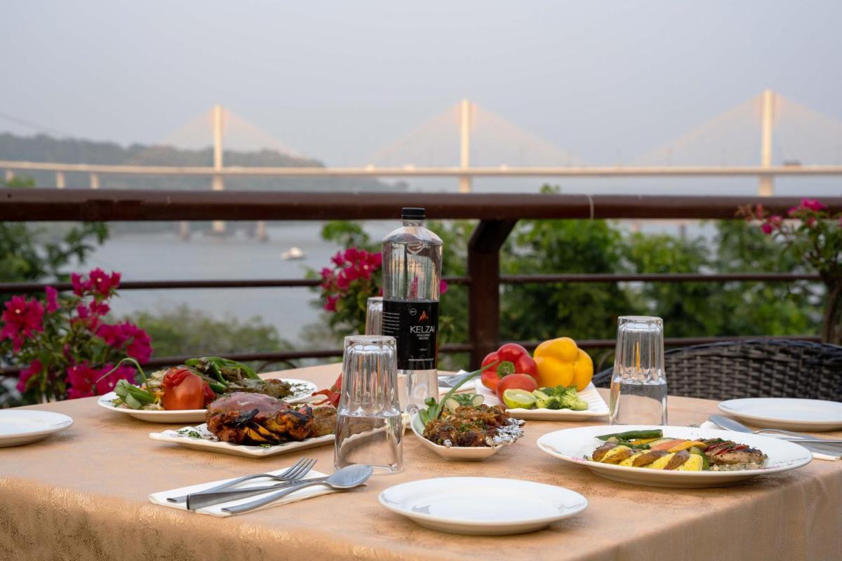 a table with plates of food and a bottle of wine at The Crown Goa in Panaji