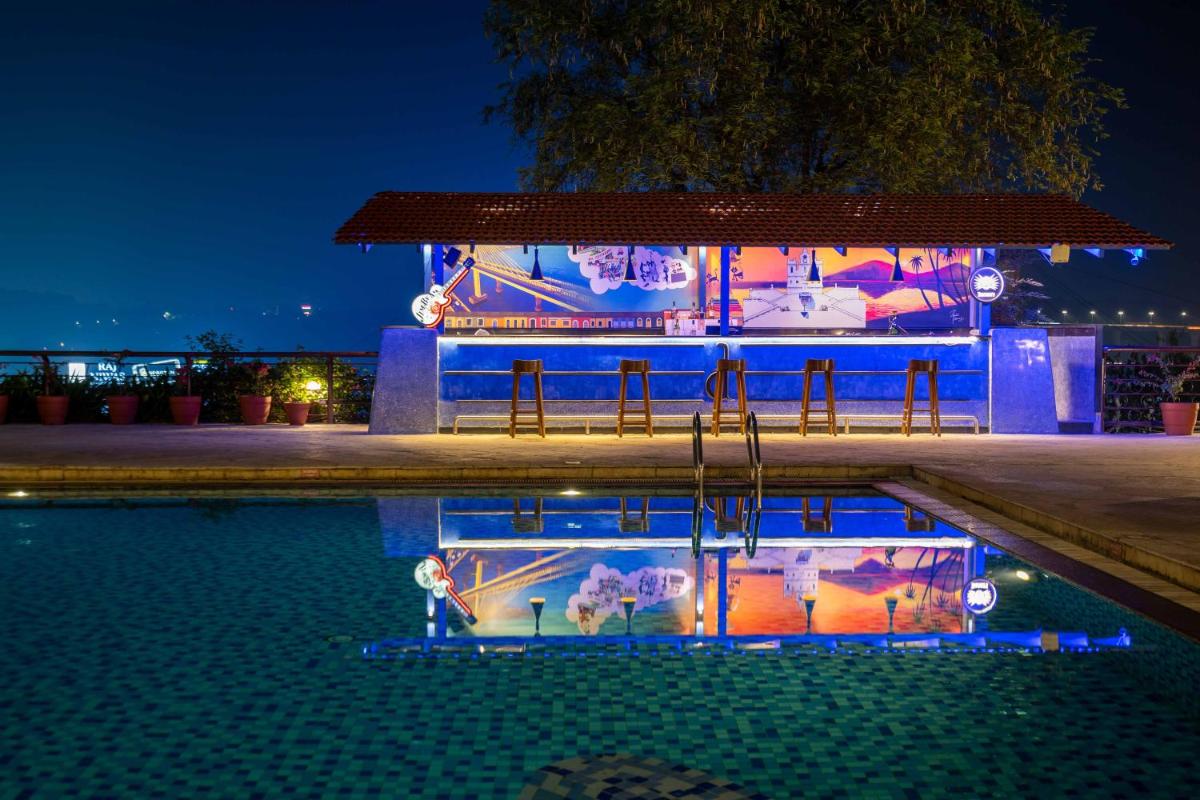 a resort with a swimming pool at night at The Crown Goa in Panaji