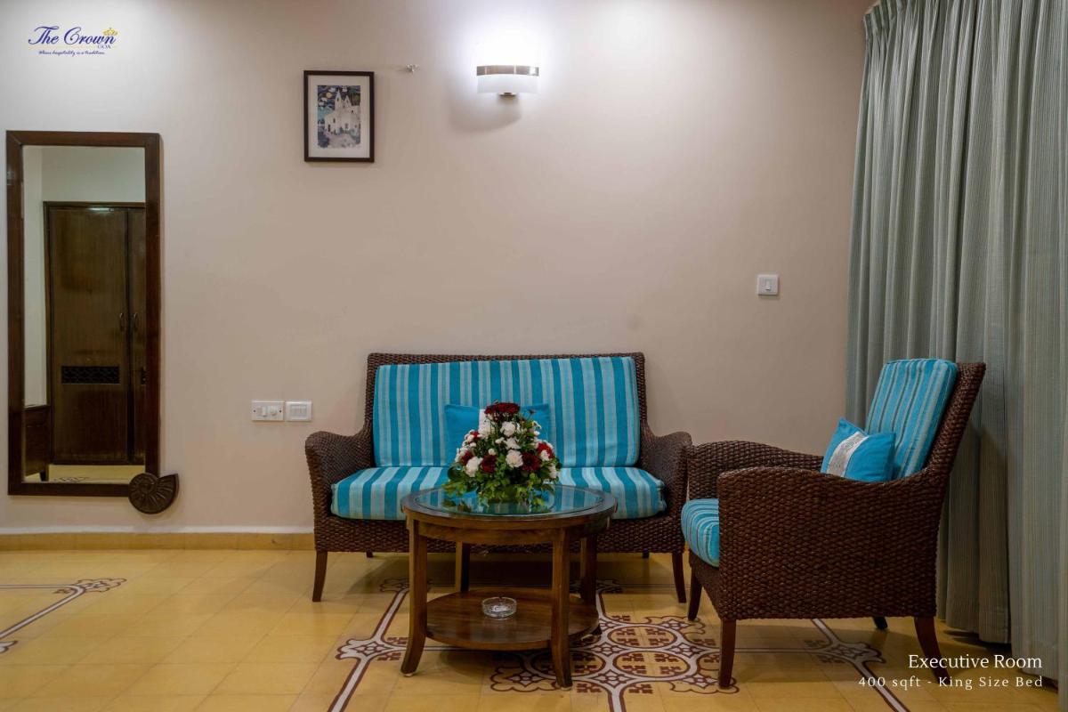 a living room with two chairs and a table at The Crown Goa in Panaji