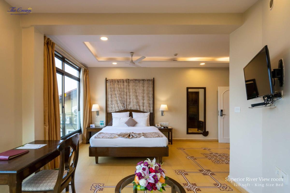 a hotel room with a bed and a desk and a desk at The Crown Goa in Panaji
