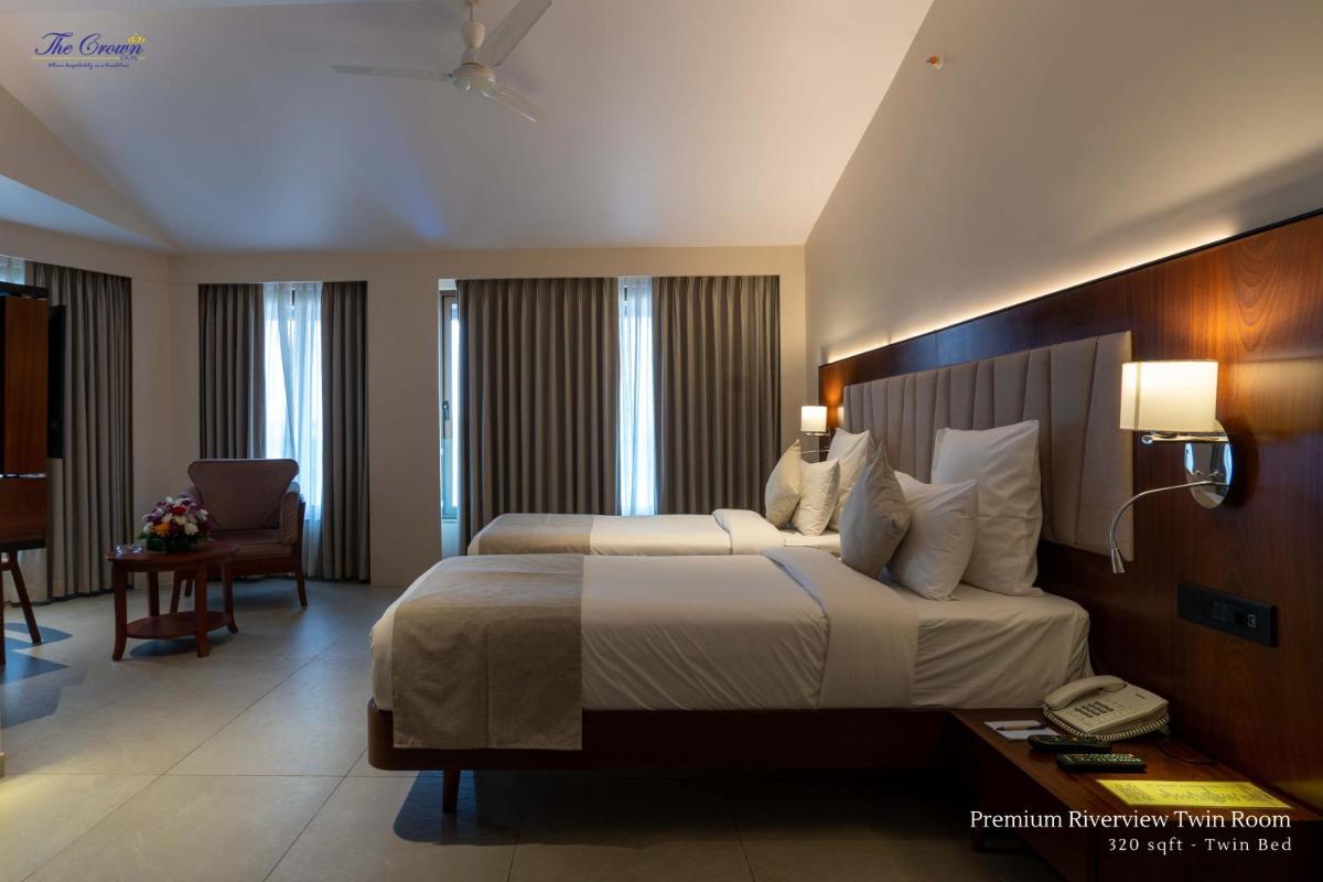 a hotel room with a large bed and a desk at The Crown Goa in Panaji