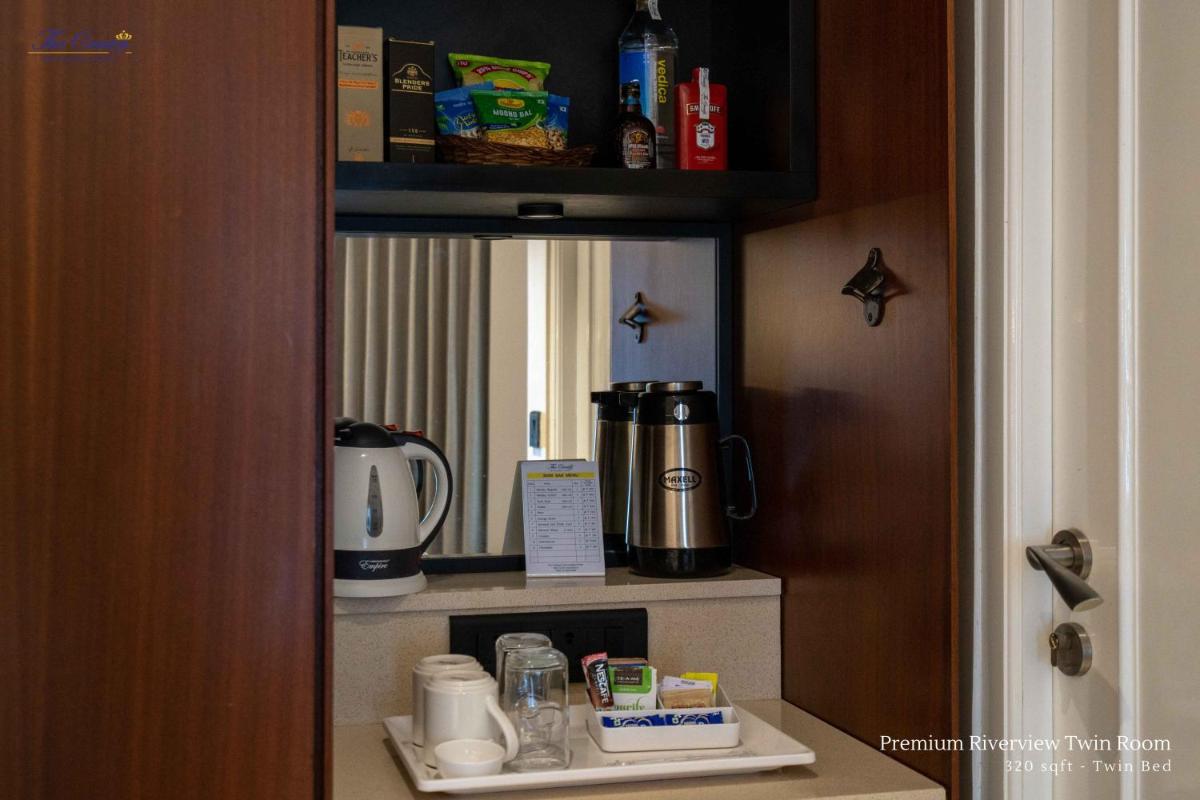 a cupboard with a coffee maker on a shelf at The Crown Goa in Panaji
