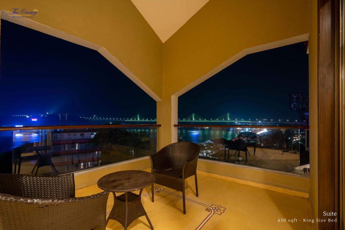 a balcony with a view of the city at night at The Crown Goa in Panaji