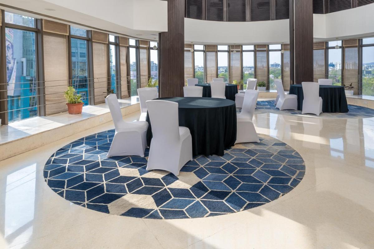 a conference room with tables and white chairs at Sunday Hotel Jaipur in Jaipur