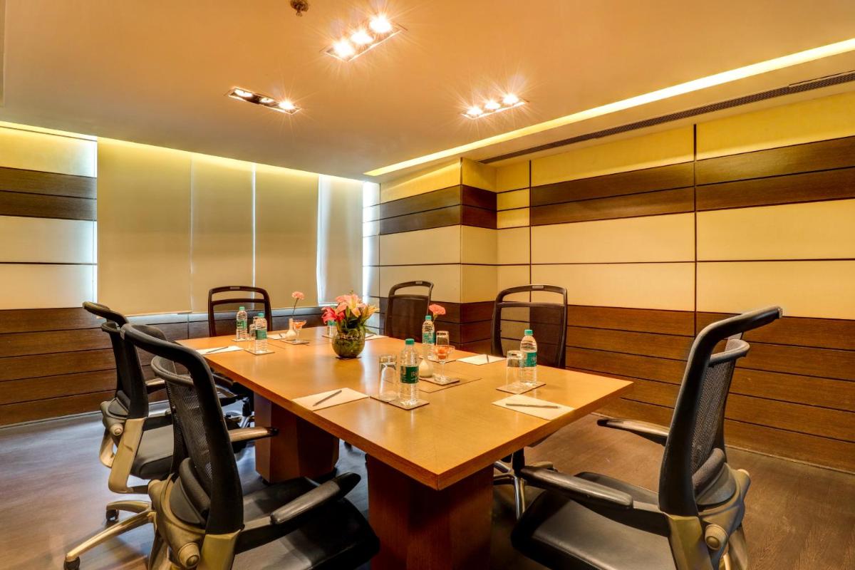 a conference room with a wooden table and chairs at Sunday Hotel Jaipur in Jaipur