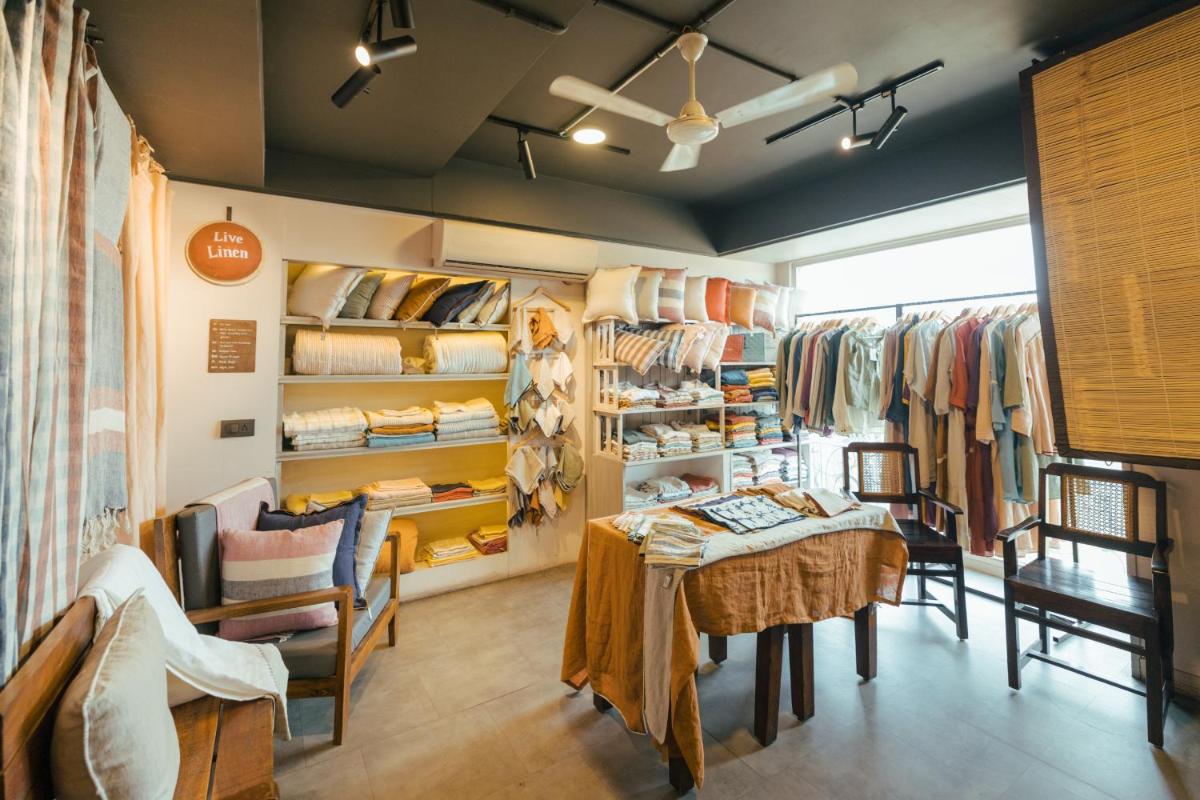 a clothing store with a table and chairs and racks of clothes at Sunday Hotel Jaipur in Jaipur