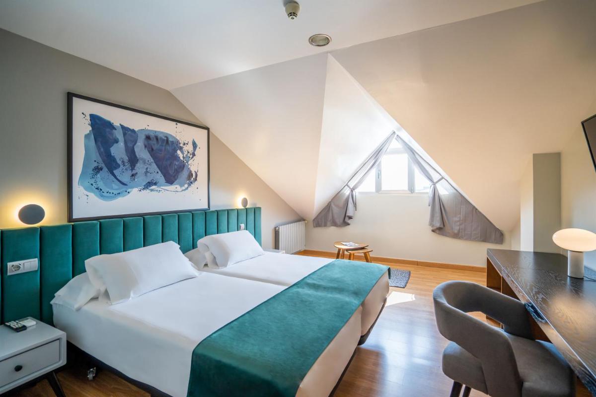 Un dormitorio con una cama grande con cabecero verde. en Abba Comillas Hotel, en Comillas