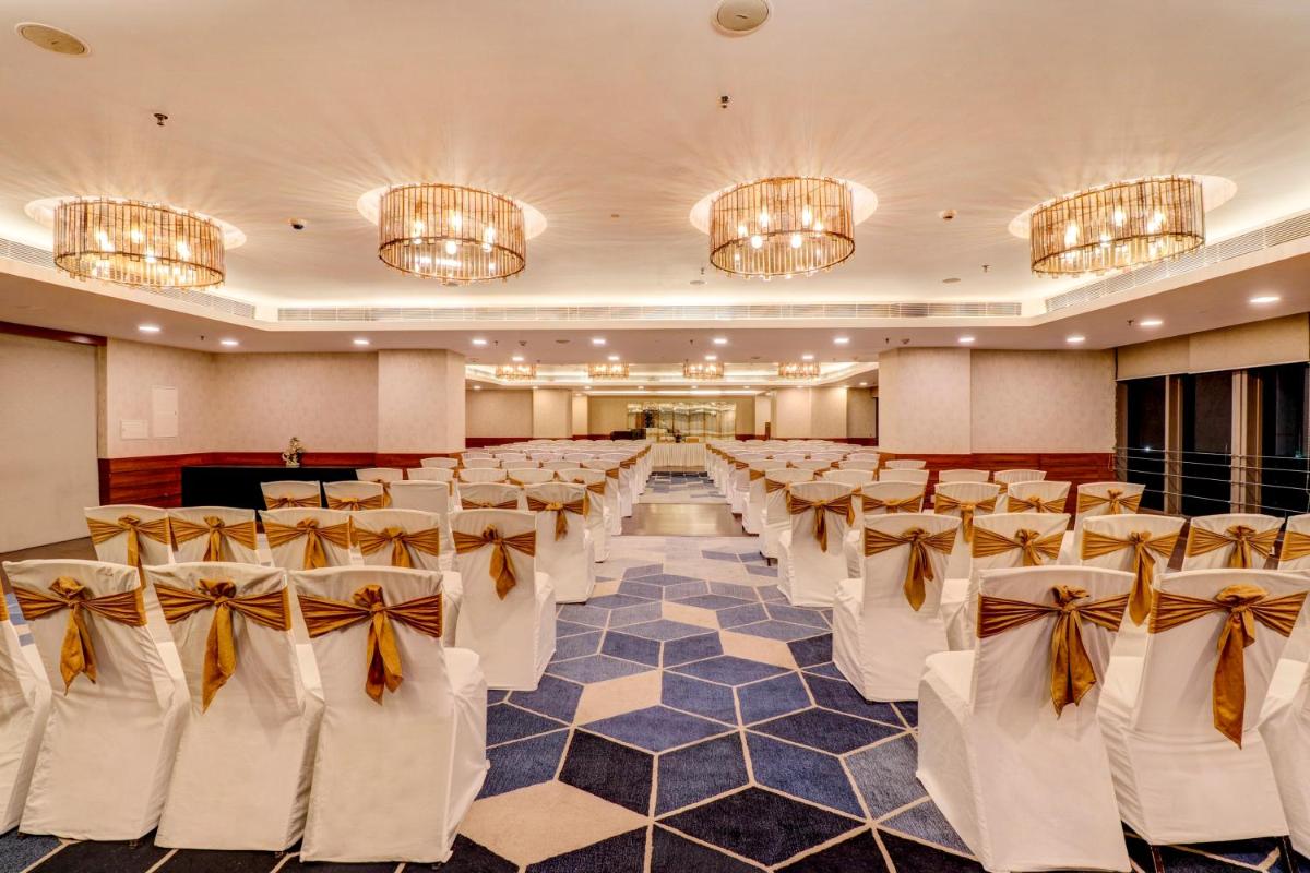 a banquet hall with rows of chairs in a room with chandeliers at Sunday Hotel Jaipur in Jaipur