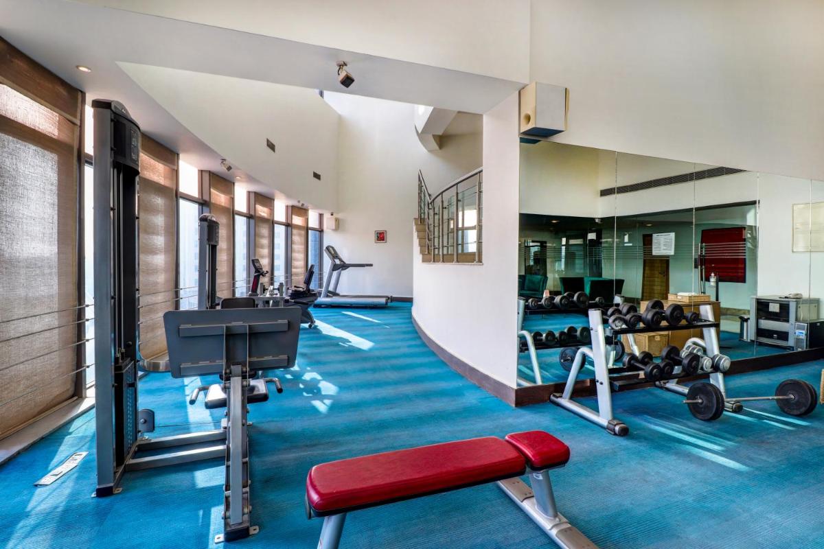 a gym with treadmills and weights in a building at Sunday Hotel Jaipur in Jaipur