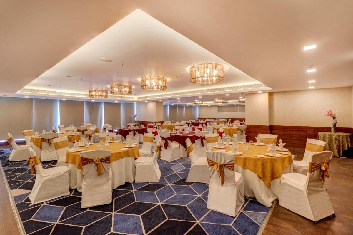 a banquet hall with tables and chairs and chandeliers at Sunday Hotel Jaipur in Jaipur +61 photos