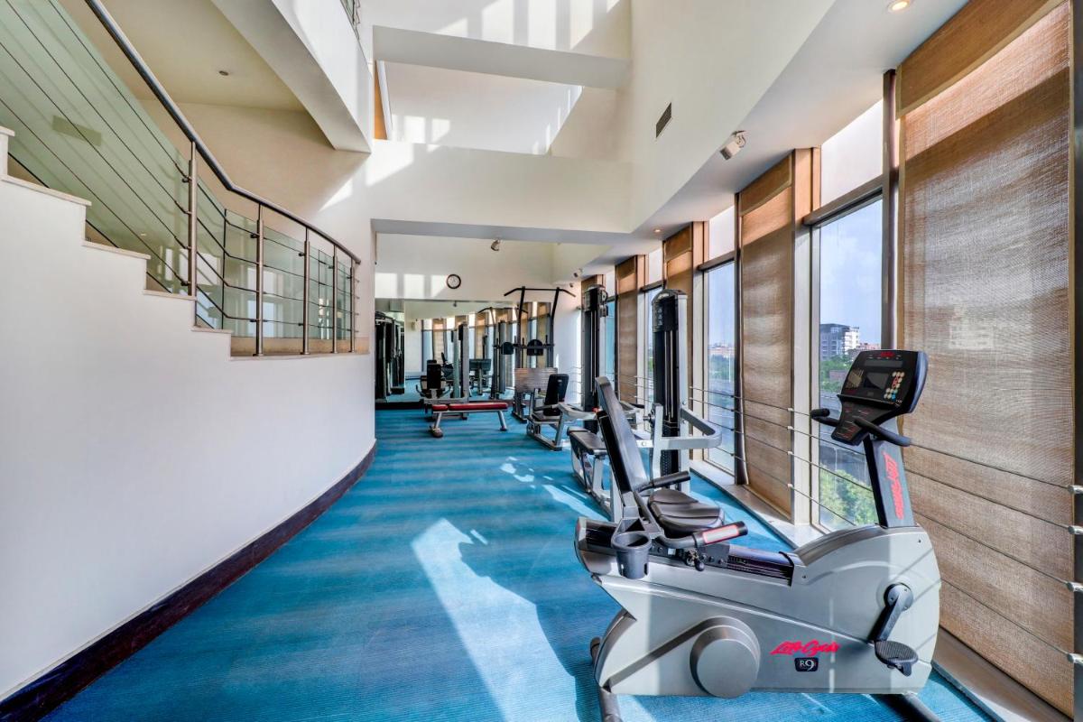 a gym with treadmills and elliptical machines at Sunday Hotel Jaipur in Jaipur