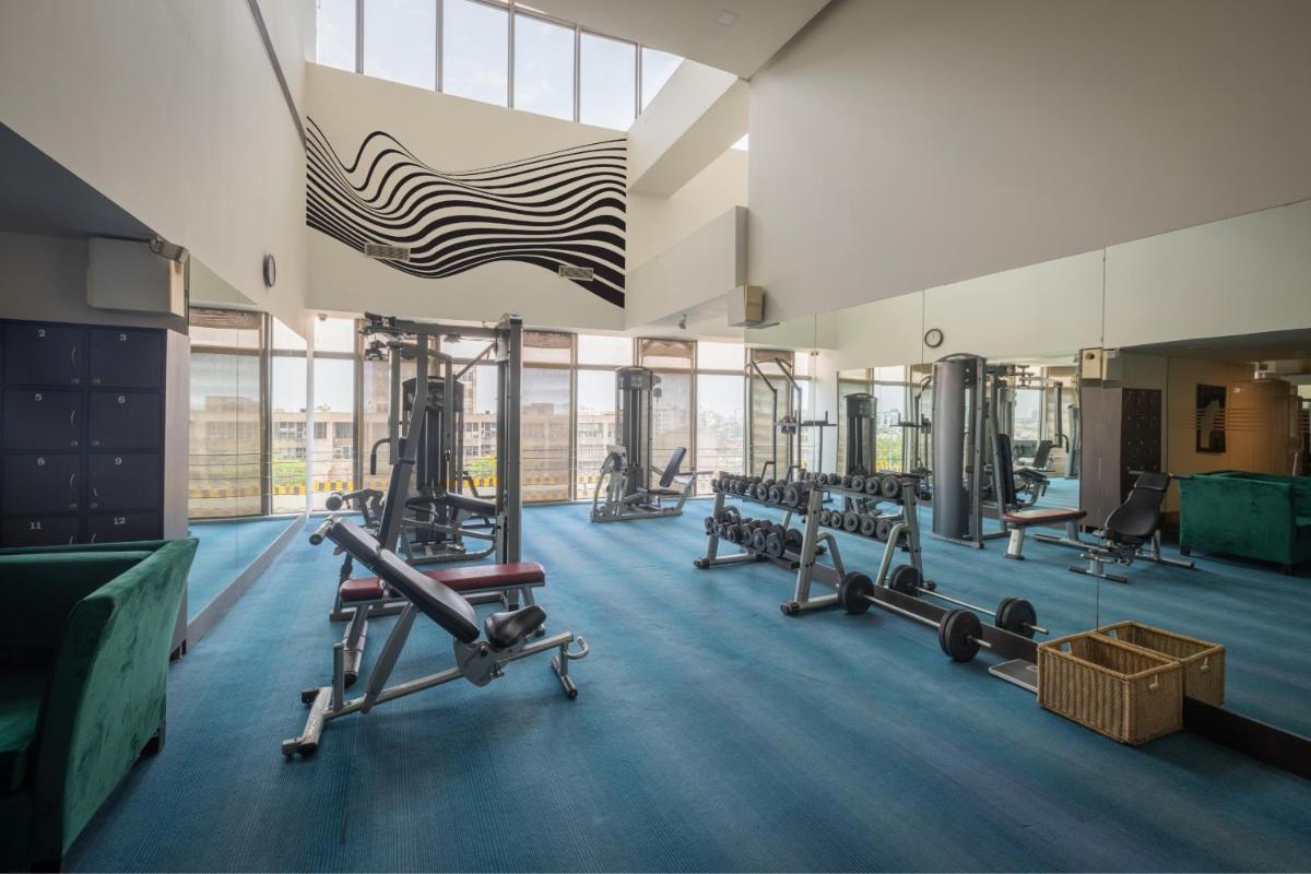 a gym with several tread machines and a large window at Sunday Hotel Jaipur in Jaipur