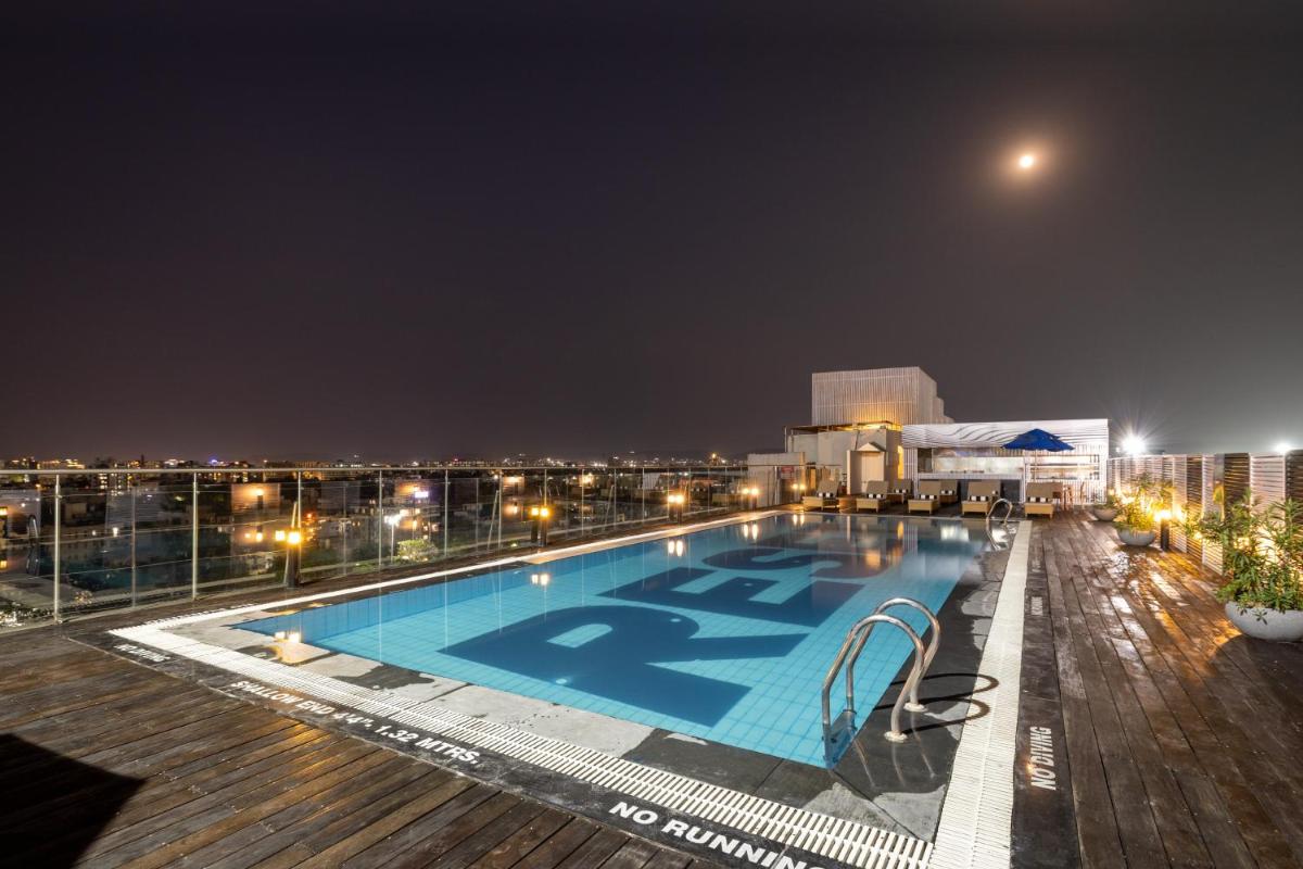 a swimming pool on top of a building at night at Sunday Hotel Jaipur in Jaipur