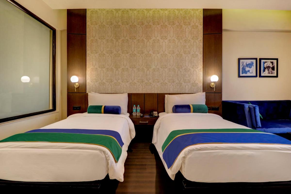 a hotel room with two beds and a tv at Sunday Hotel Jaipur in Jaipur