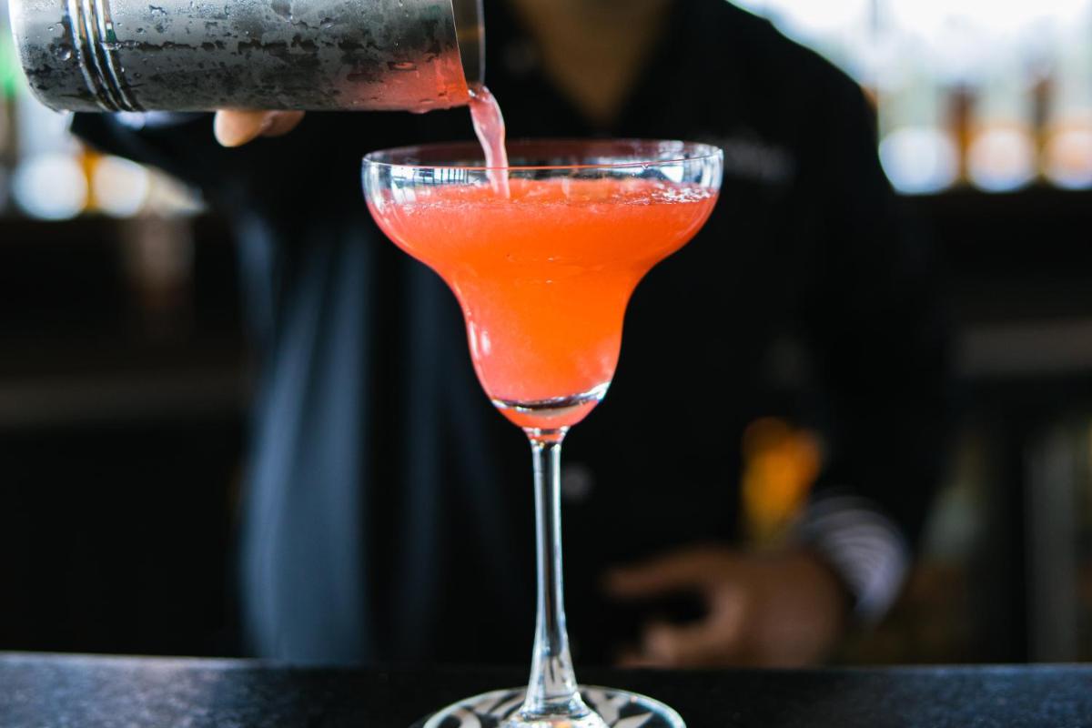 a drink being poured into a cocktail glass at Sunday Hotel Jaipur in Jaipur