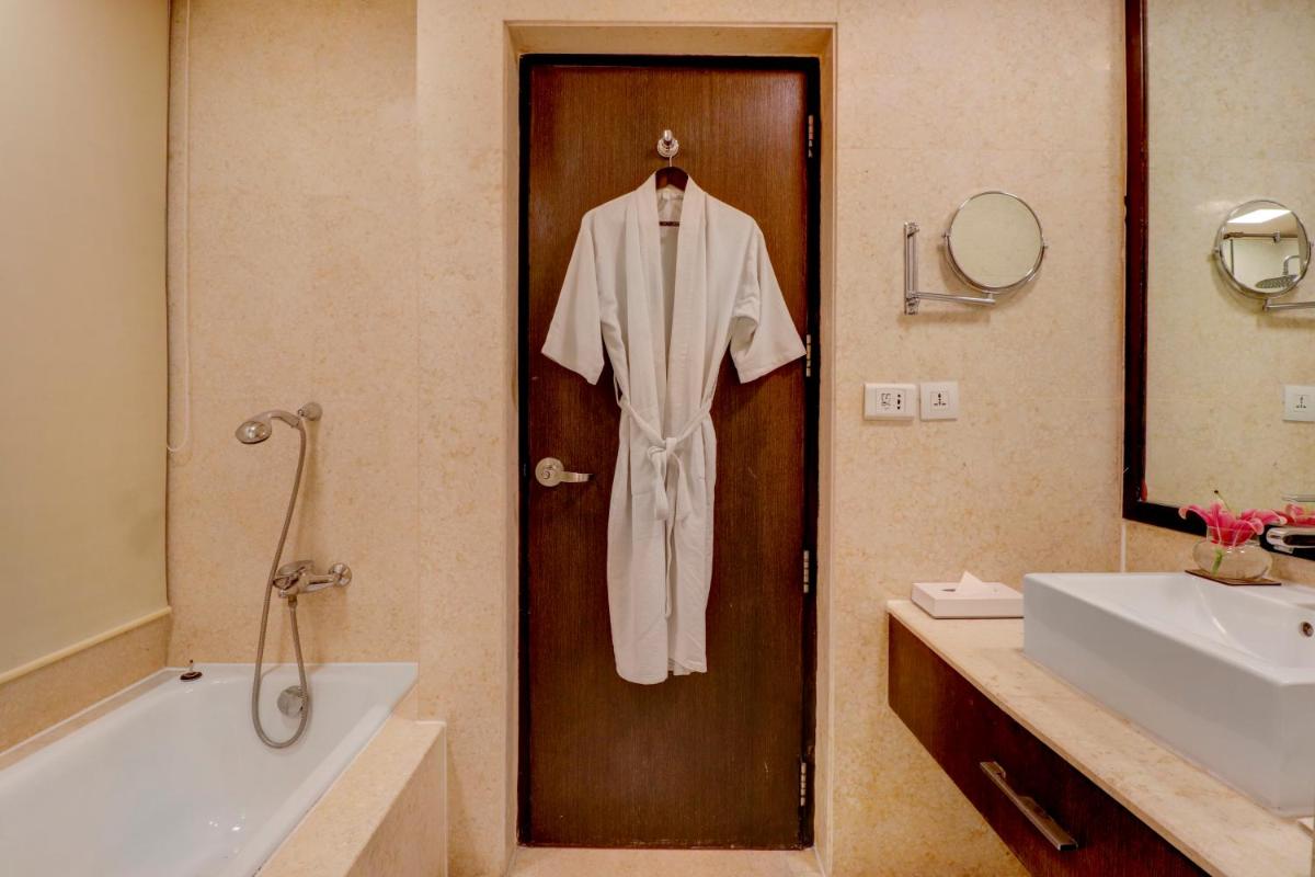 a robe hanging on a door in a bathroom at Sunday Hotel Jaipur in Jaipur
