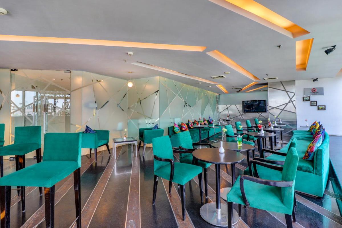 a dining room with green chairs and tables at Sunday Hotel Jaipur in Jaipur