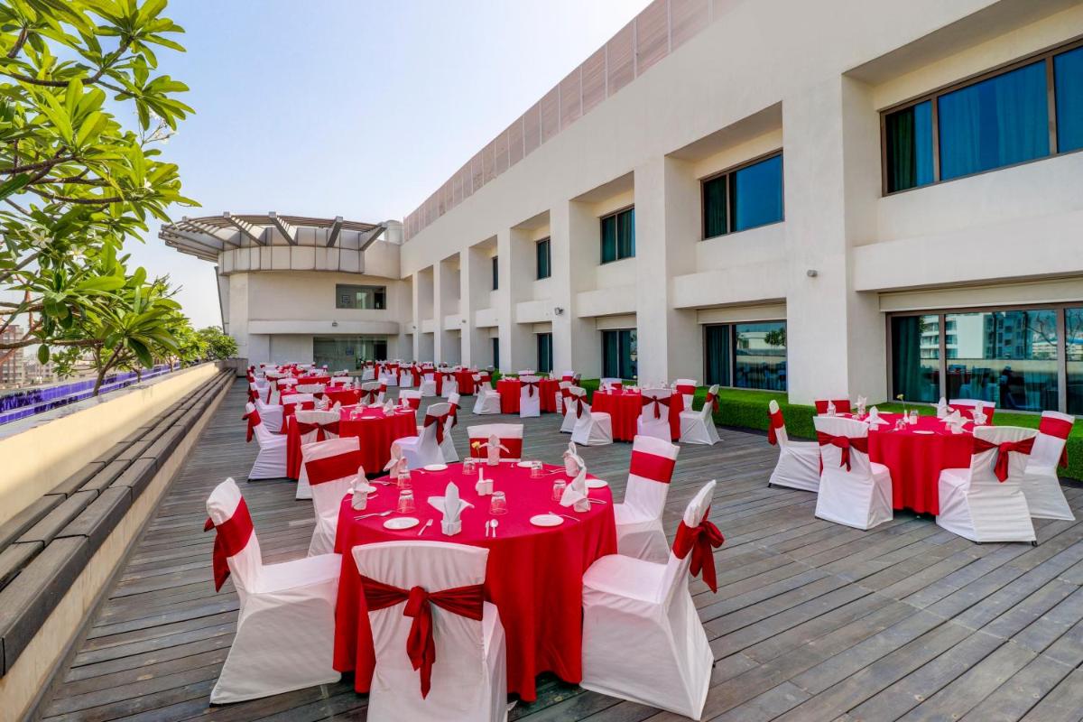 a banquet hall with red and white tables and chairs at Sunday Hotel Jaipur in Jaipur