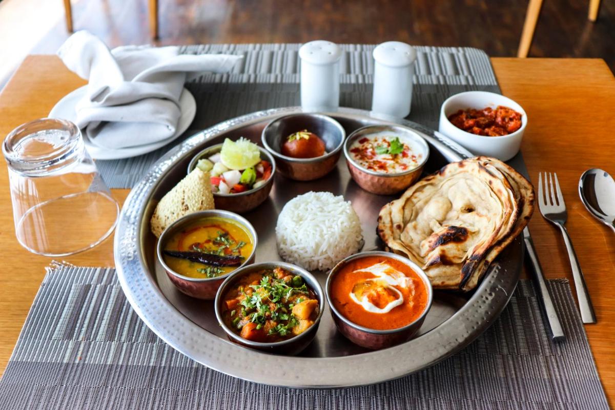 a plate of food on a table with rice at Sunday Hotel Jaipur in Jaipur