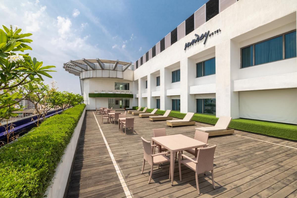 a row of tables and chairs in front of a building at Sunday Hotel Jaipur in Jaipur