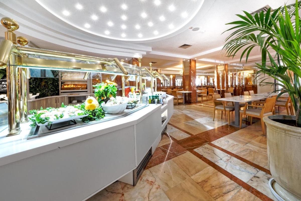 un restaurante con un buffet con mesas y plantas en Bull Dorado Beach & SPA, en La Playa de Arguineguín