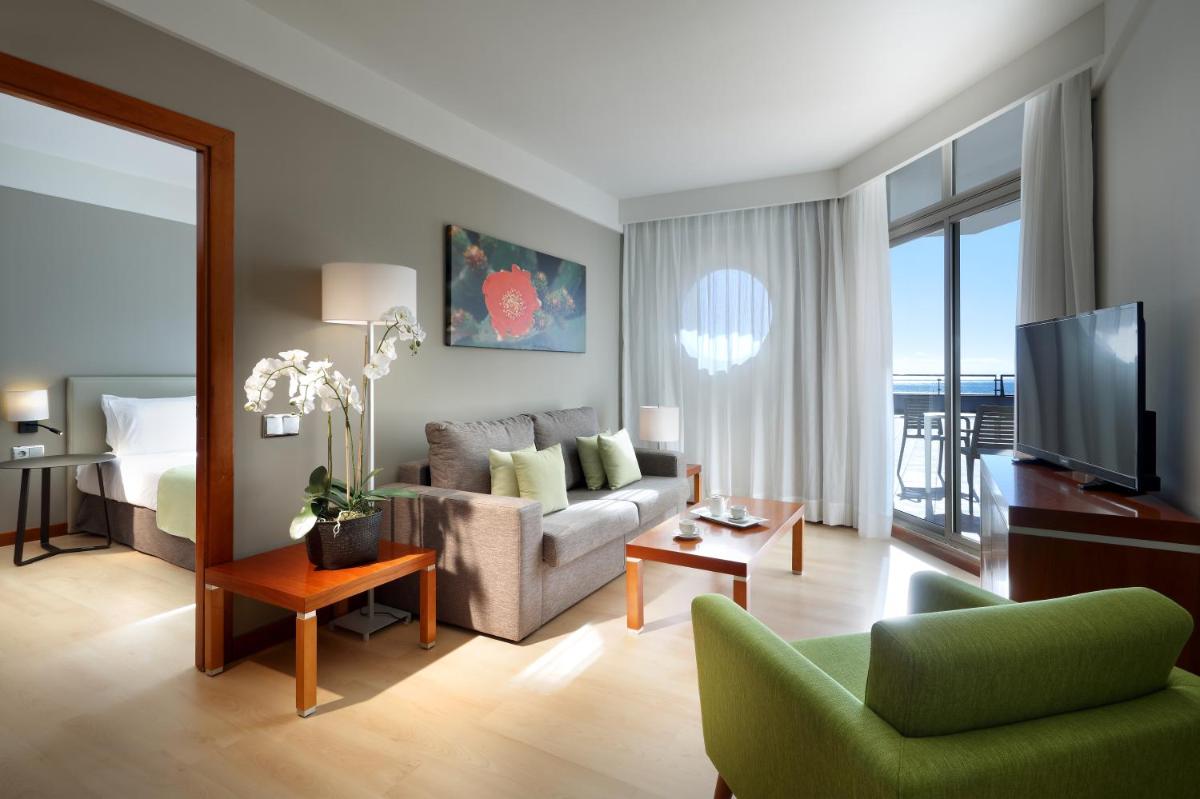 Una sala de estar con un sofá y un televisor. en Eurostars Las Salinas, en Caleta de Fuste