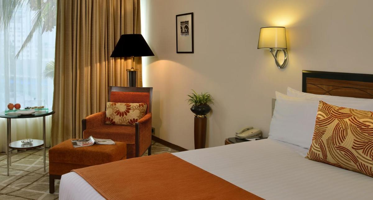 a hotel room with a bed and a chair at Hotel Marine Plaza in Mumbai