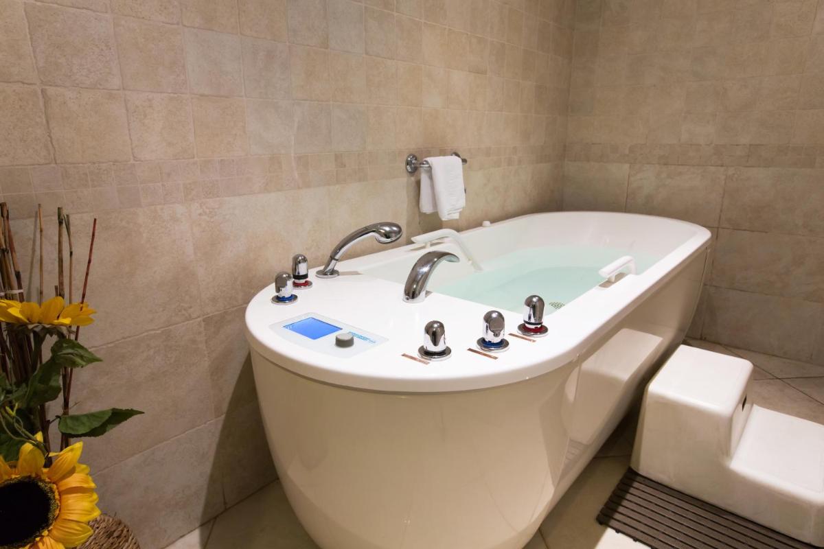 une salle de bains avec lavabo et baignoire dans l'établissement Hotel *** & Spa Vacances Bleues Villa Marlioz, à Aix-les-Bains