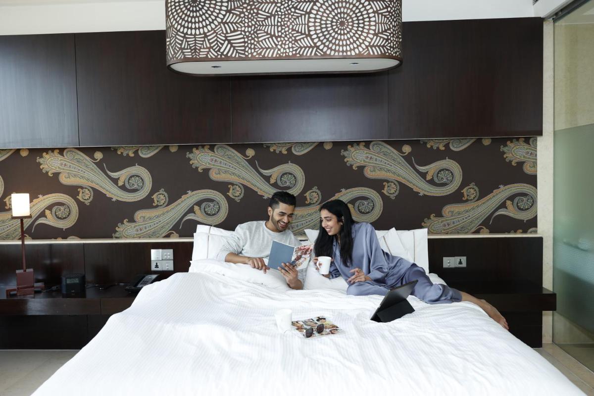 a man and a woman laying on a bed at The Westin Gurgaon, New Delhi in Gurgaon