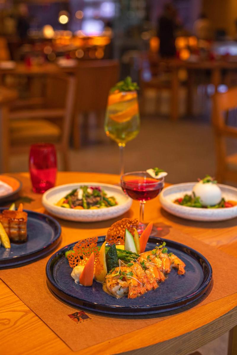 a table with plates of food and a glass of wine at The Westin Gurgaon, New Delhi in Gurgaon