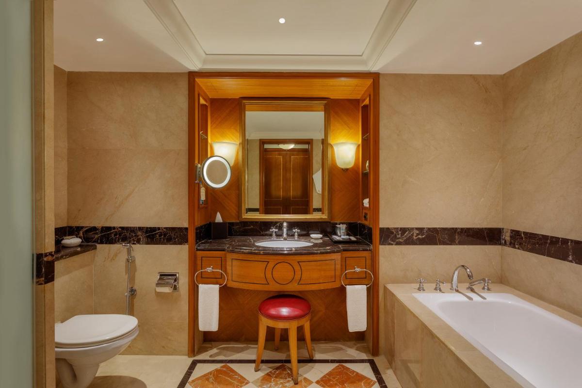 a bathroom with a tub and a toilet and a sink at ITC Maurya, a Luxury Collection Hotel, New Delhi in New Delhi a bathroom with a tub and a toilet and a sink at ITC Maurya, a Luxury Collection Hotel, New Delhi in New Delhi