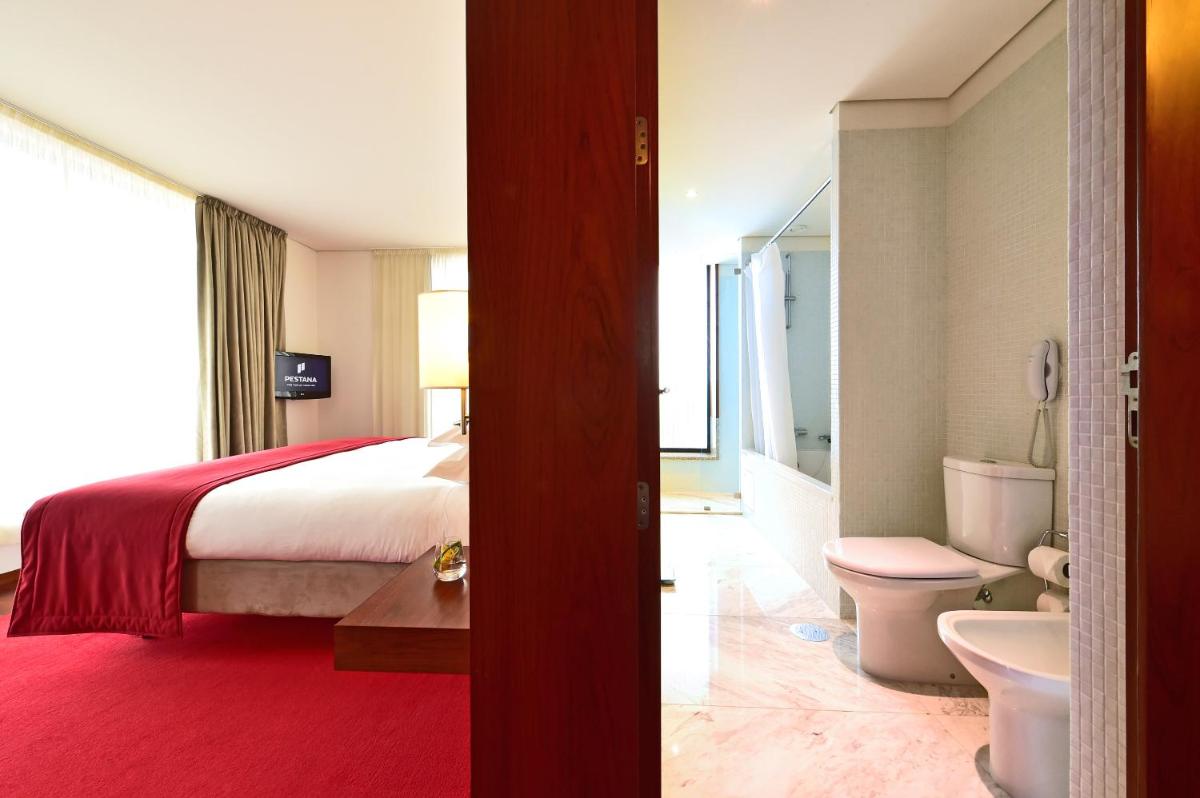 um quarto com uma cama e um banheiro com vaso sanitário em Pousada De Viseu em Viseu