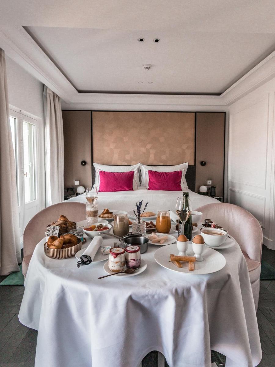 une table avec de la nourriture devant un lit dans l'établissement Fauchon l'Hôtel Paris, à Paris 37 autres photos