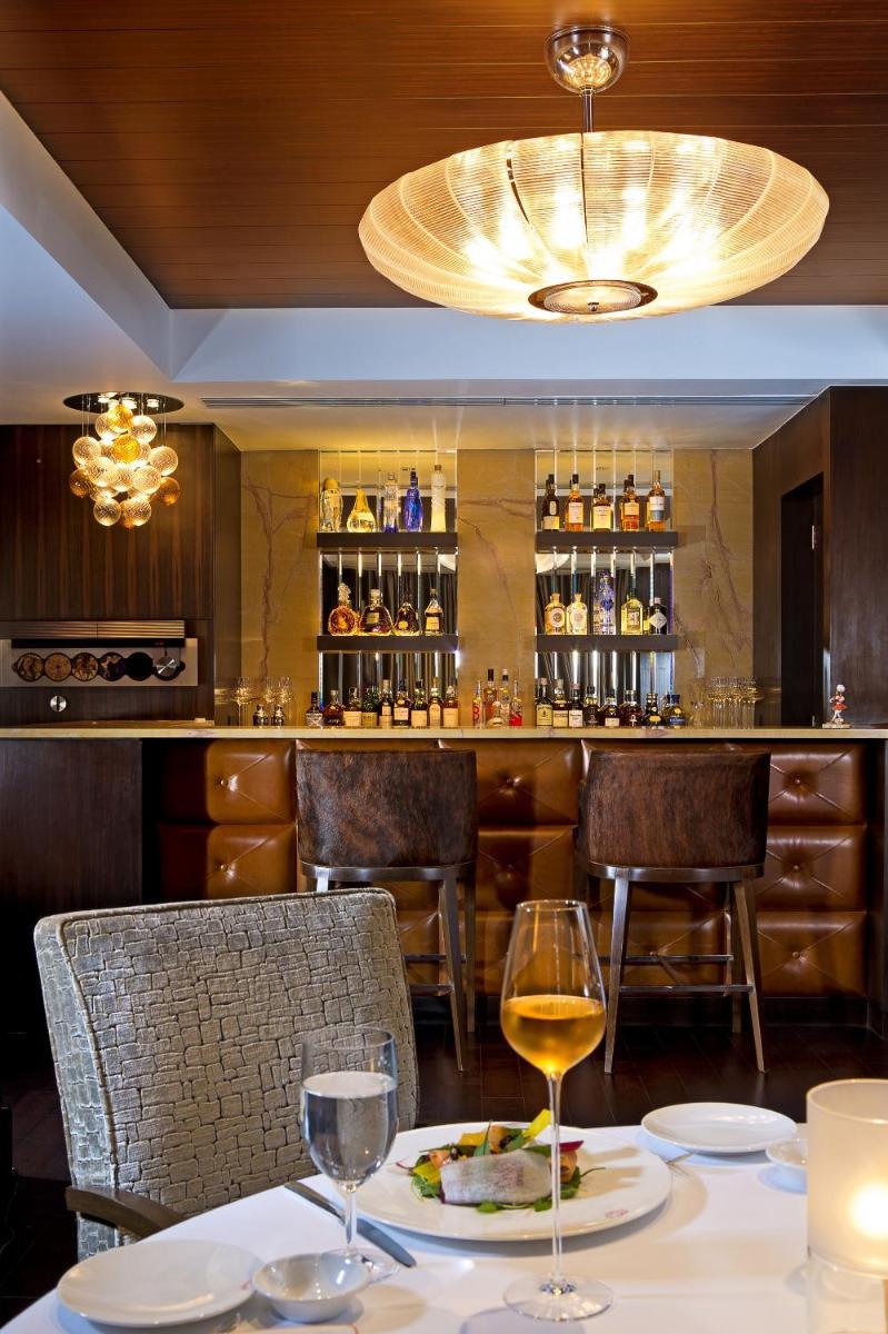 a restaurant with a table with two glasses of wine at The Leela Mumbai in Mumbai a restaurant with a table with two glasses of wine at The Leela Mumbai in Mumbai