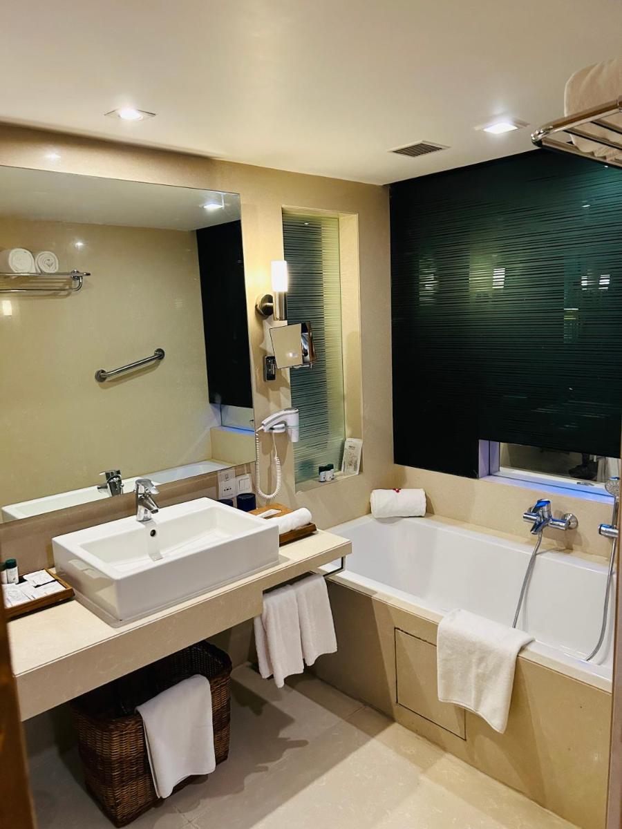 a bathroom with a large tub and a sink at Fortune Select SG Highway, Ahmedabad - Member ITC Hotels' Group in Ahmedabad