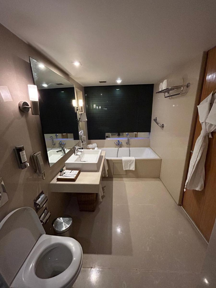 a bathroom with a toilet and a sink and a tub at Fortune Select SG Highway, Ahmedabad - Member ITC Hotels' Group in Ahmedabad