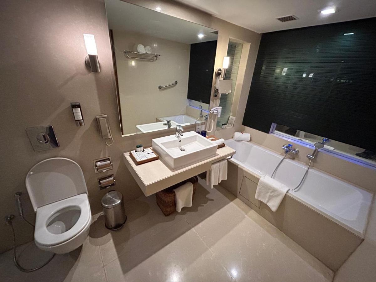 a bathroom with a toilet and a sink and a tub at Fortune Select SG Highway, Ahmedabad - Member ITC Hotels' Group in Ahmedabad