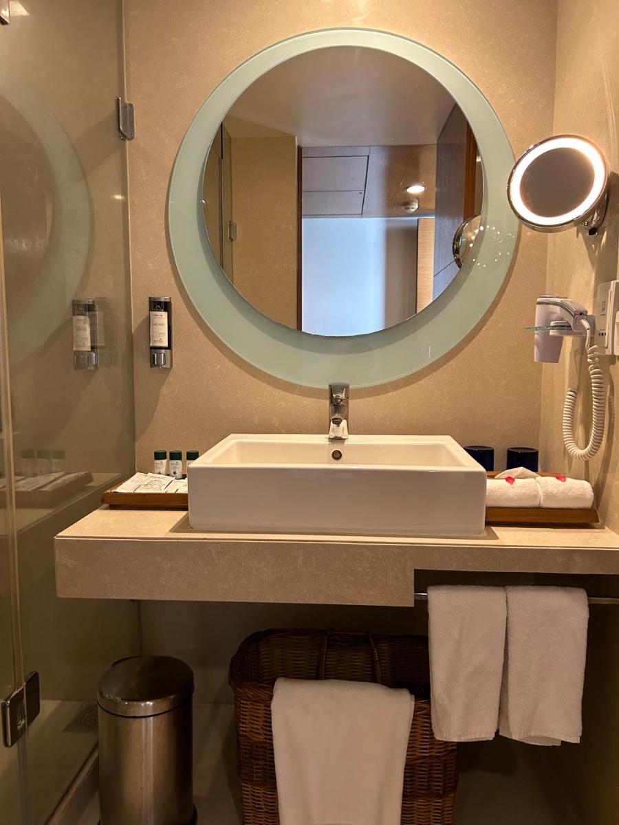a bathroom with a sink and a large mirror at Fortune Select SG Highway, Ahmedabad - Member ITC Hotels' Group in Ahmedabad