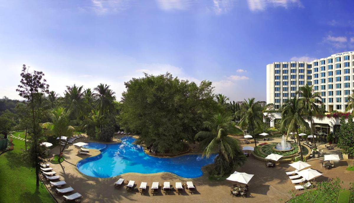 an overhead view of a pool at a resort at The Leela Mumbai in Mumbai an overhead view of a pool at a resort at The Leela Mumbai in Mumbai