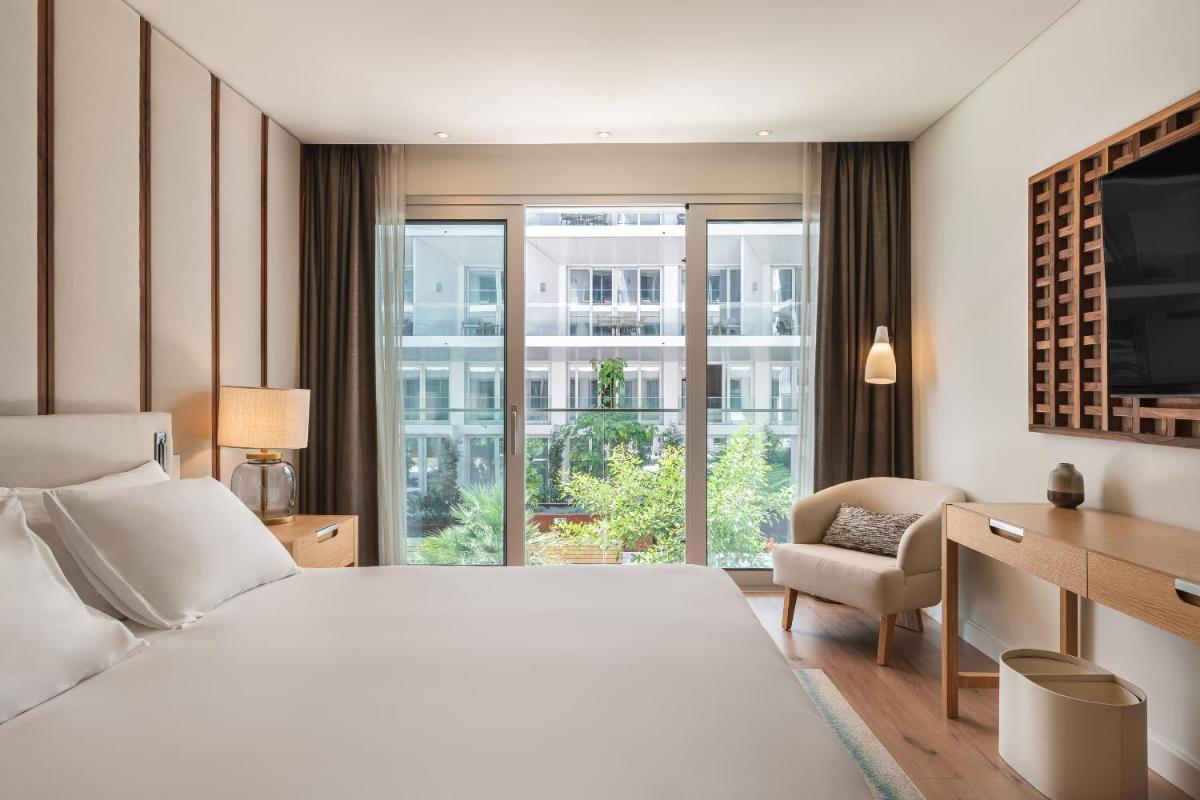 um quarto de hotel com uma cama, uma escrivaninha e uma janela em Hyatt Regency Lisbon em Lisboa