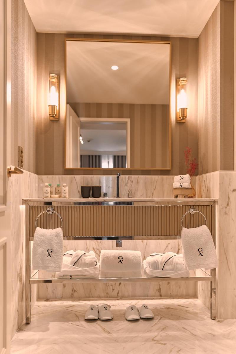 um banheiro com pia e espelho em GA Palace Hotel & Spa, a XIXth-Century Villa no Porto