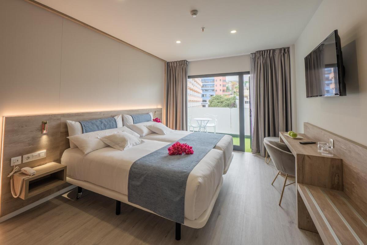 Una habitación de hotel con una cama, un escritorio y un televisor. en Hotel AF Valle Orotava, en Puerto de la Cruz