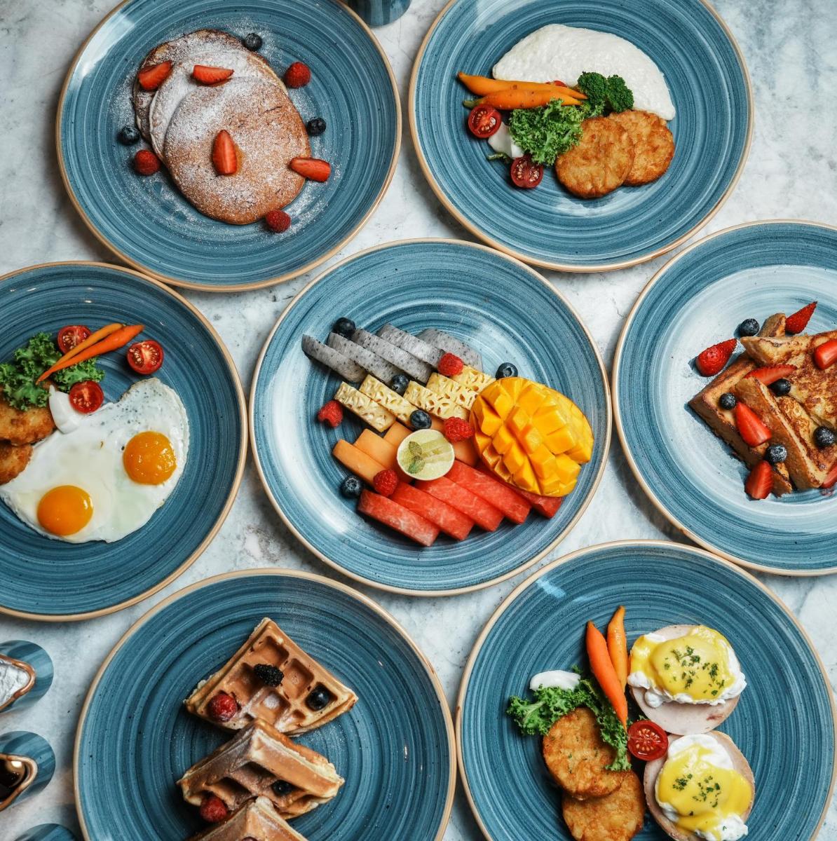 a group of blue plates of food on a table at Courtyard by Marriott Mahabaleshwar in Mahabaleshwar