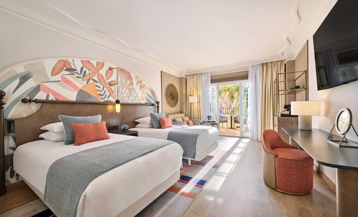 Una habitación de hotel con dos camas y un escritorio. en Grand Hyatt La Manga Club Golf & Spa, en La Manga del Mar Menor